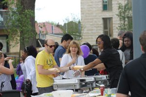 People being served food at the BBQ.