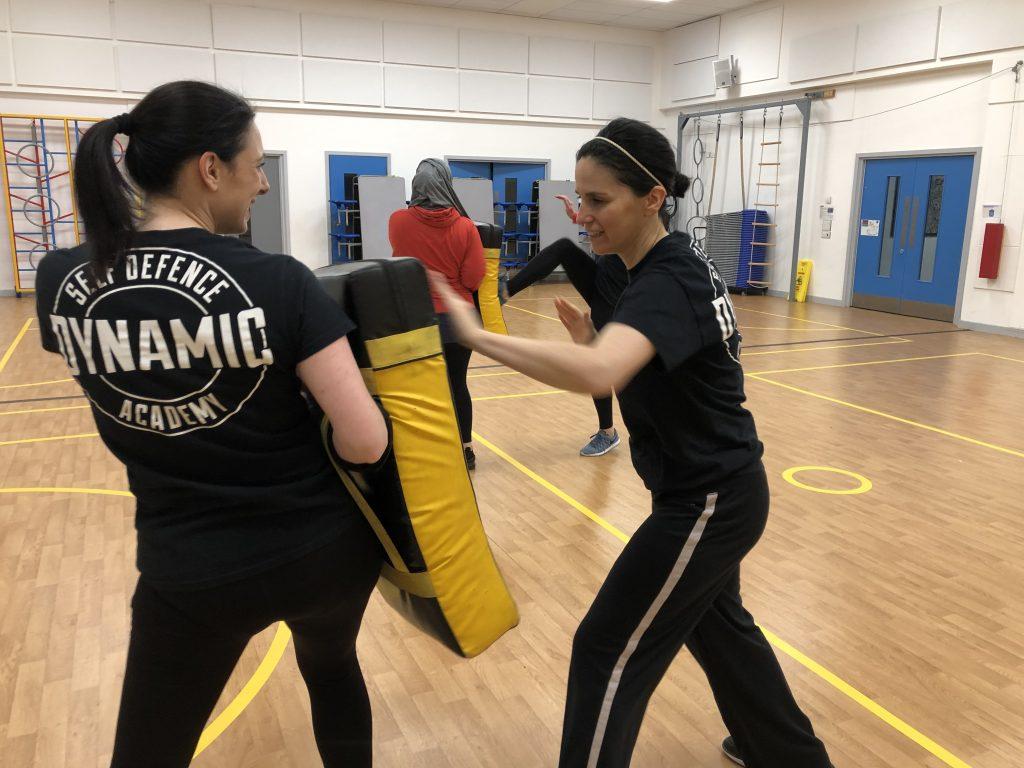 Two women taking part in a self defence class.